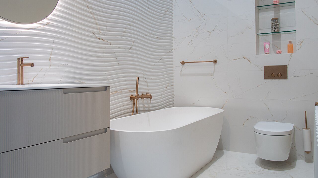Bathroom renovation with marble look wall tiles and a freestanding tub in St. Catharines, Ontario, by BGM Construction LTD