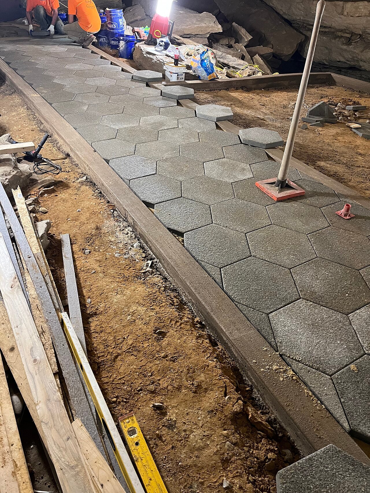 Workers laying interlocking paving stones with edge restraints for a St. Catharines home, by BGM Construction LTD