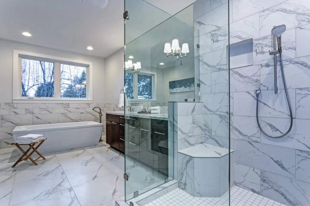 Luxurious renovated bathroom with marble-look tiles, glass walk-in shower and freestanding bathtub