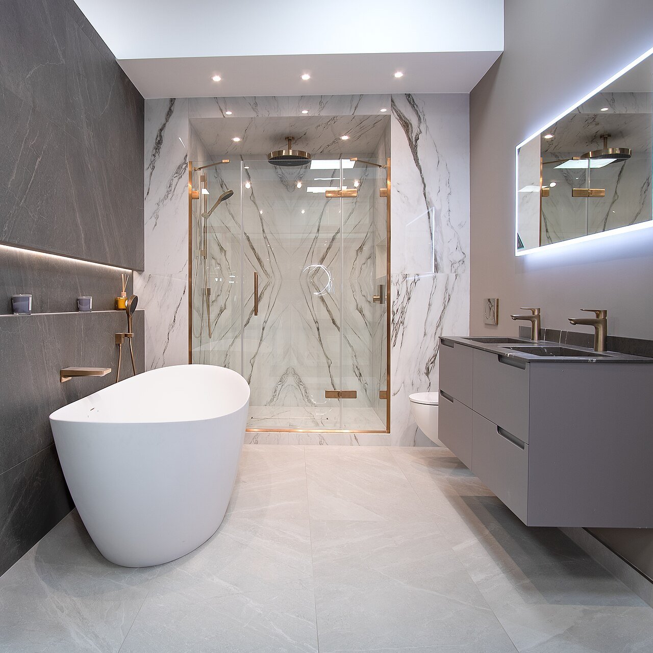 Clean luxury bathroom with a marble tiled shower, glass doors and a freestanding tub.