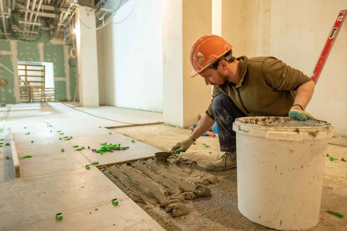 tile-installation-welland.webp Tile installer laying floor tile in Welland, tile installation by BGM Construction LTD