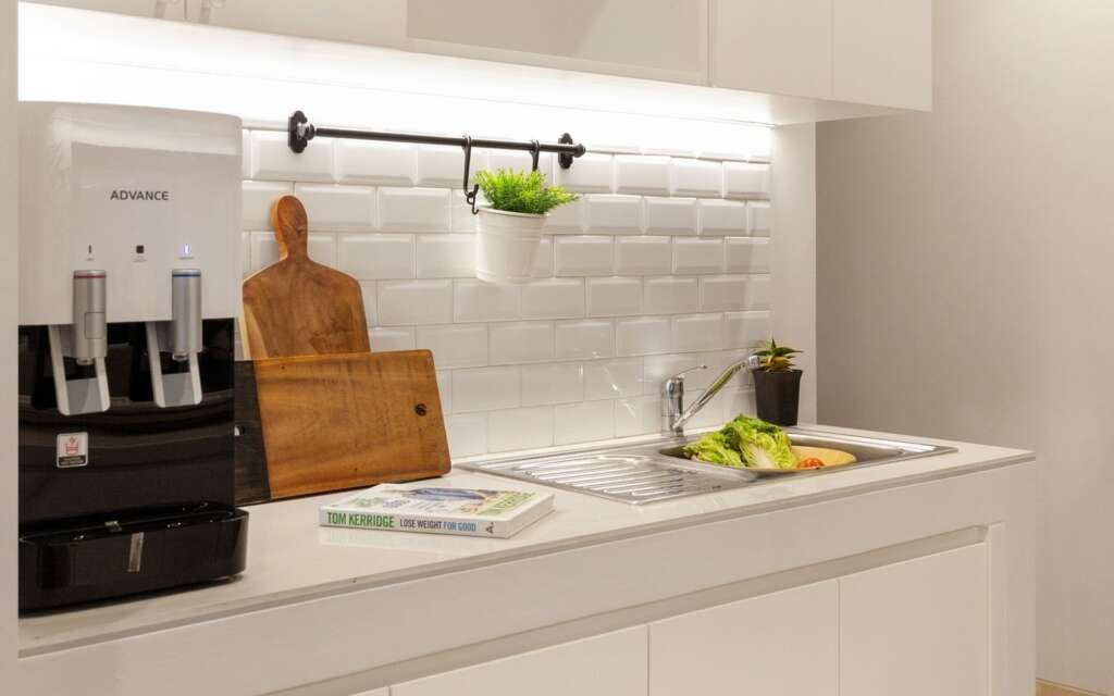 White subway tile backsplash with light grout in a bright white kitchen.