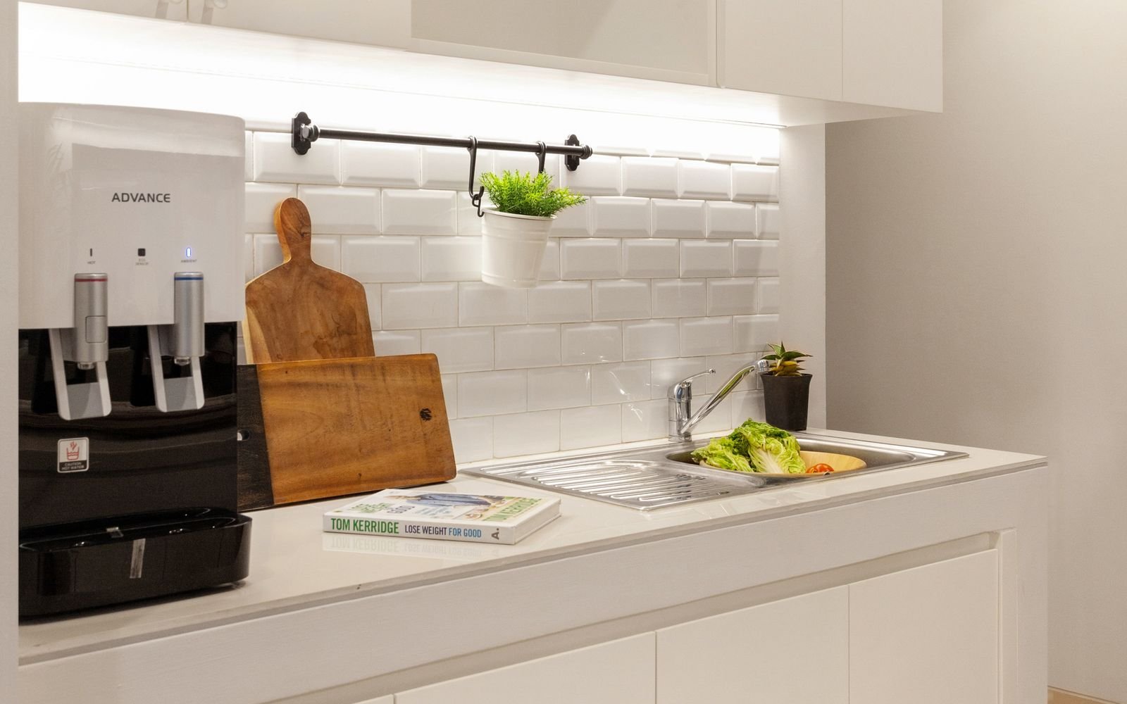 White subway tile backsplash with light grout in a bright white kitchen.